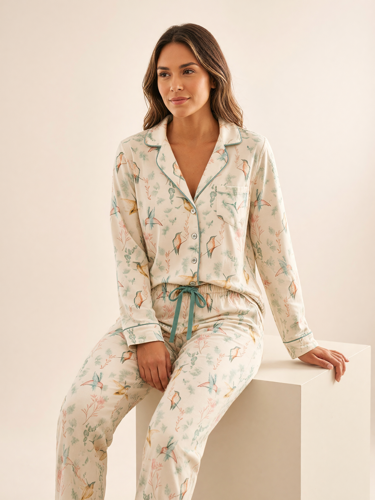 Mujer sentada con pijama Alas de Agua Felicita Palmeto de algodón Pima, en estudio. Imagen generada con IA sobre la prenda real.