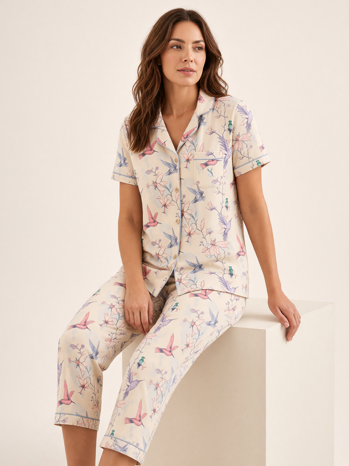 Mujer sentada con pijama Dream Garden Fascino Natural de algodón Pima, en estudio. Imagen generada con IA sobre la prenda real.