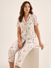 Mujer sentada con pijama Dream Garden Fascino Natural de algodón Pima, en estudio. Imagen generada con IA sobre la prenda real.