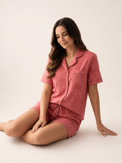 Mujer sentada con pijama Esencia Floral Amore Coral de algodón Pima, en estudio. Imagen generada con IA sobre la prenda real.