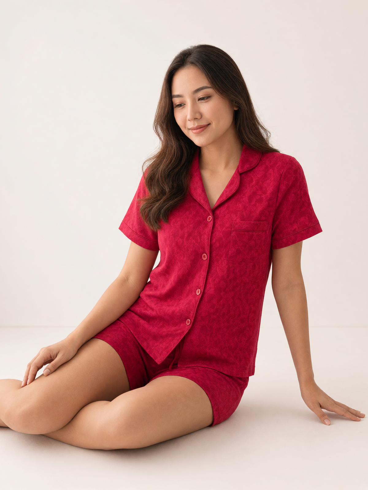 Mujer sentada con pijama Esencia Floral Amore Rosa de algodón Pima, en estudio. Imagen generada con IA sobre la prenda real.