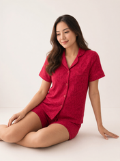 Mujer sentada con pijama Esencia Floral Amore Rosa de algodón Pima, en estudio. Imagen generada con IA sobre la prenda real.