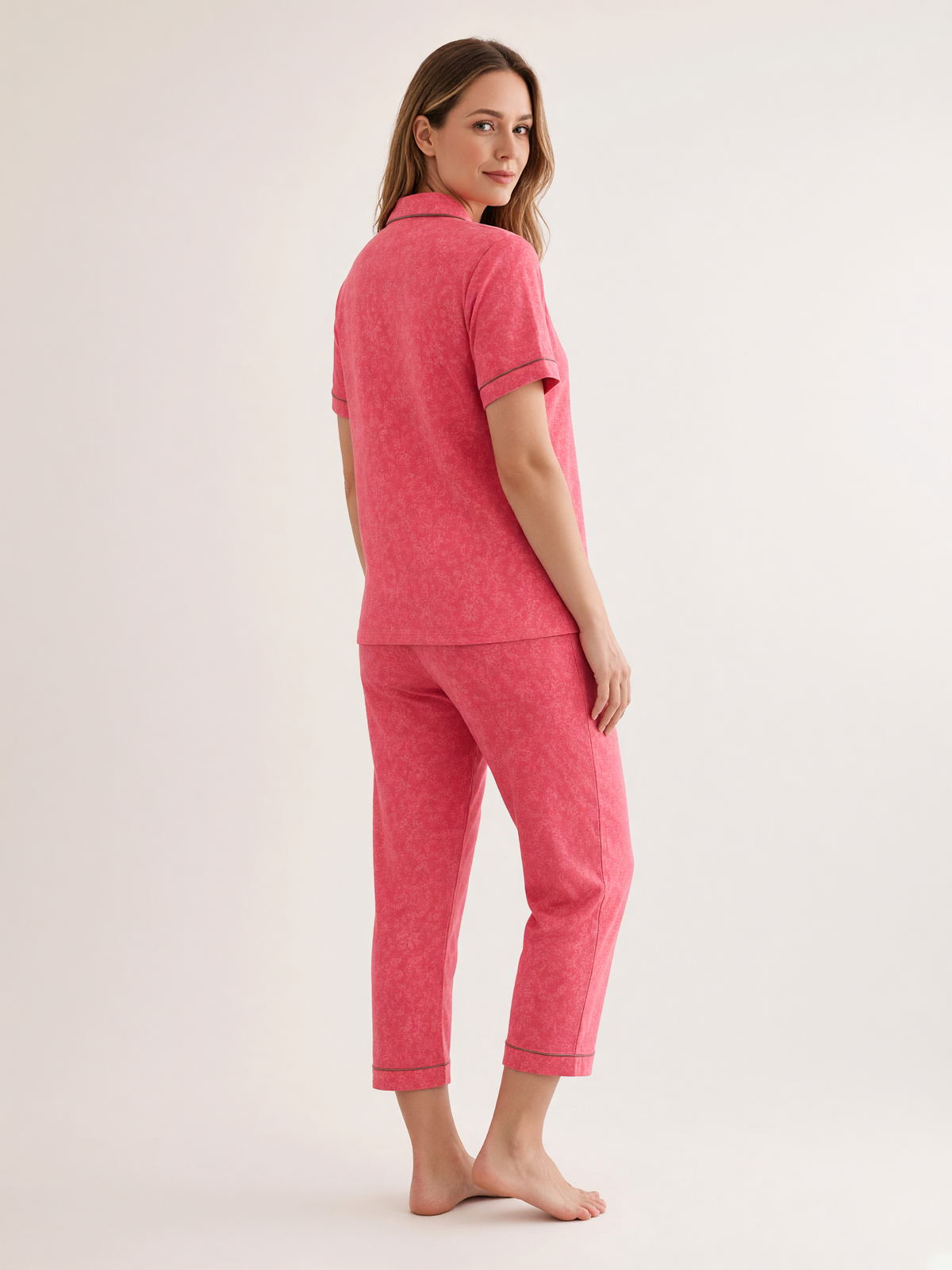 Mujer con pijama Esencia Floral Fascino Rosa de algodón Pima, de perfil en estudio. Imagen generada con IA sobre la prenda real.