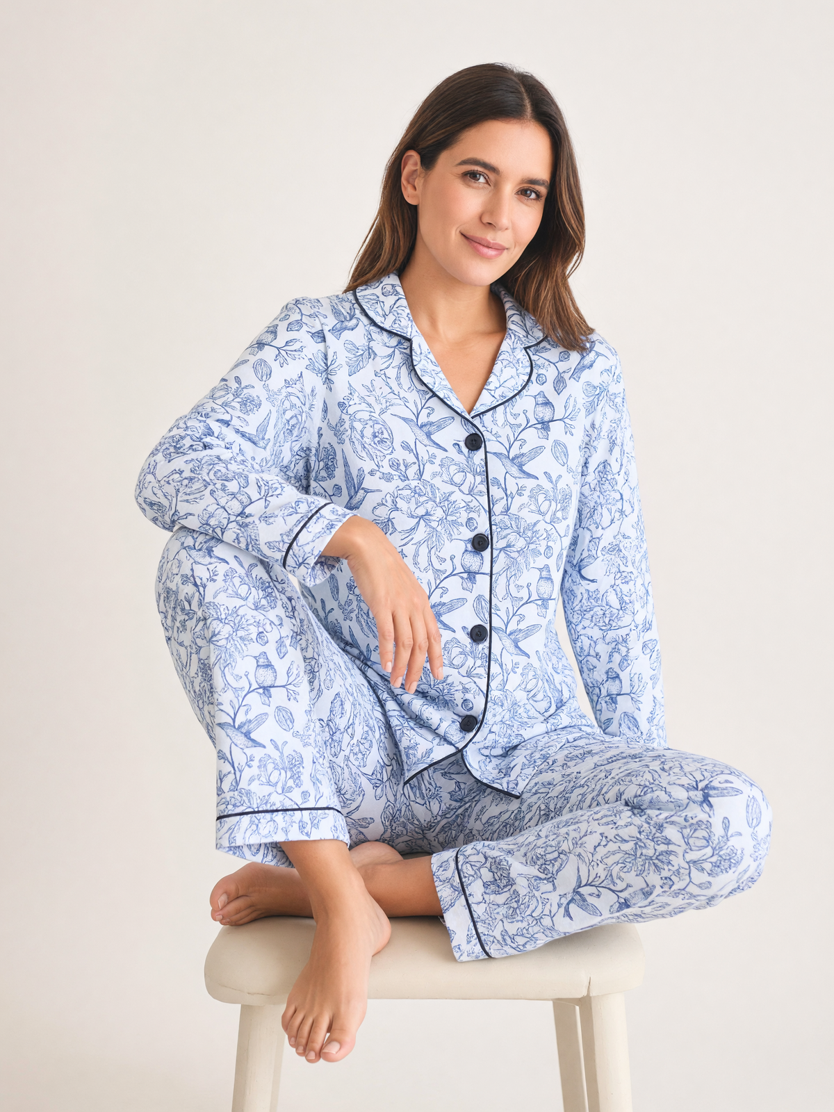 Mujer sentada con pijama Natura Eleganza Azul de algodón Pima, en estudio. Imagen generada con IA sobre la prenda real.