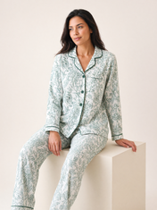 Mujer sentada con pijama Natura Eleganza Verde de algodón Pima, en estudio. Imagen generada con IA sobre la prenda real.