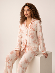 Mujer sentada con pijama Mitos Griegos Eleganza Rosa de algodón Pima, en estudio. Imagen generada con IA sobre la prenda real.