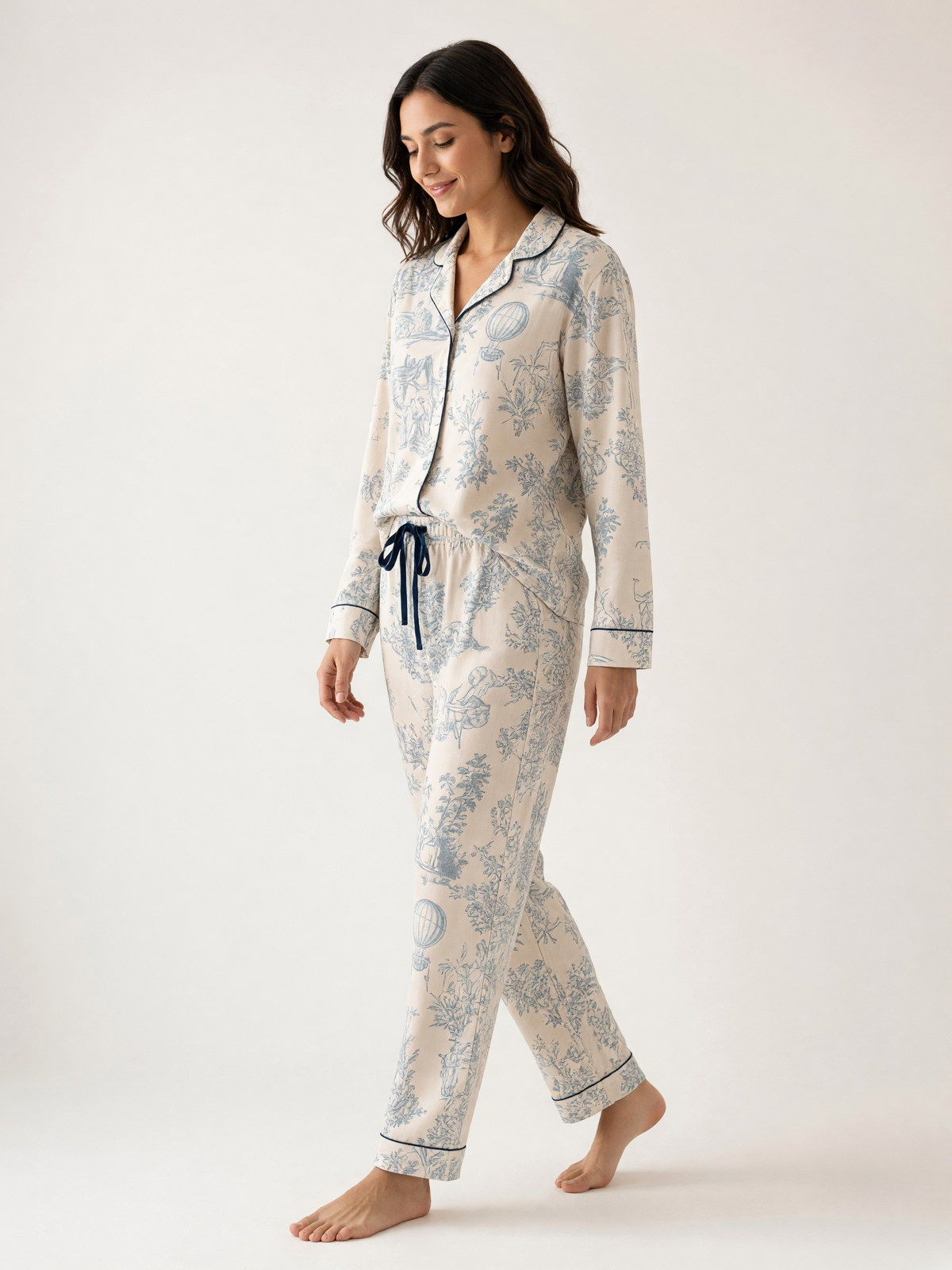 Mujer con pijama Sueños en Vintage Armonía Polvo Azul de algodón Pima, de perfil en estudio. Imagen generada con IA sobre la prenda real.