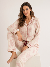 Mujer sentada con pijama Sueños en Vintage Armonía Rojo Atardecer de algodón Pima, en estudio. Imagen generada con IA sobre la prenda real.