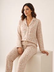 Mujer sentada con pijama Wayra Llama Felicita Natural de algodón Pima, en estudio. Imagen generada con IA sobre la prenda real.